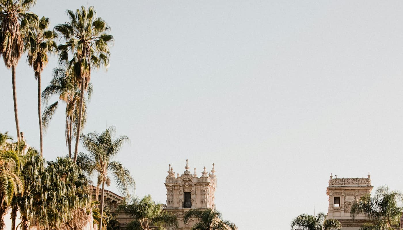 Spanish Colonial Revival architecture with palm trees in a park